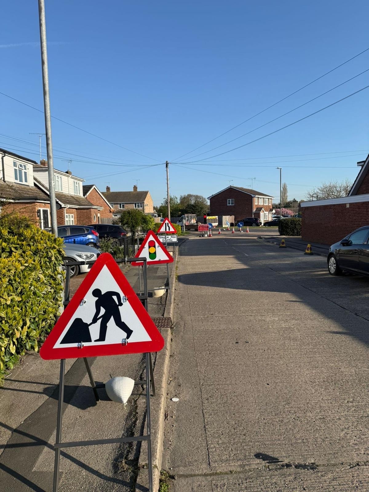 Road works ahead signs and single file traffic management on a residential road